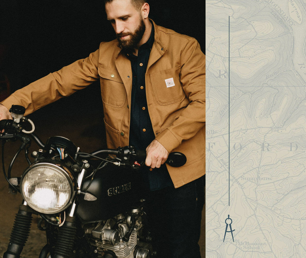 man in a sturdy Carhartt coat maneuvering a motorcycle