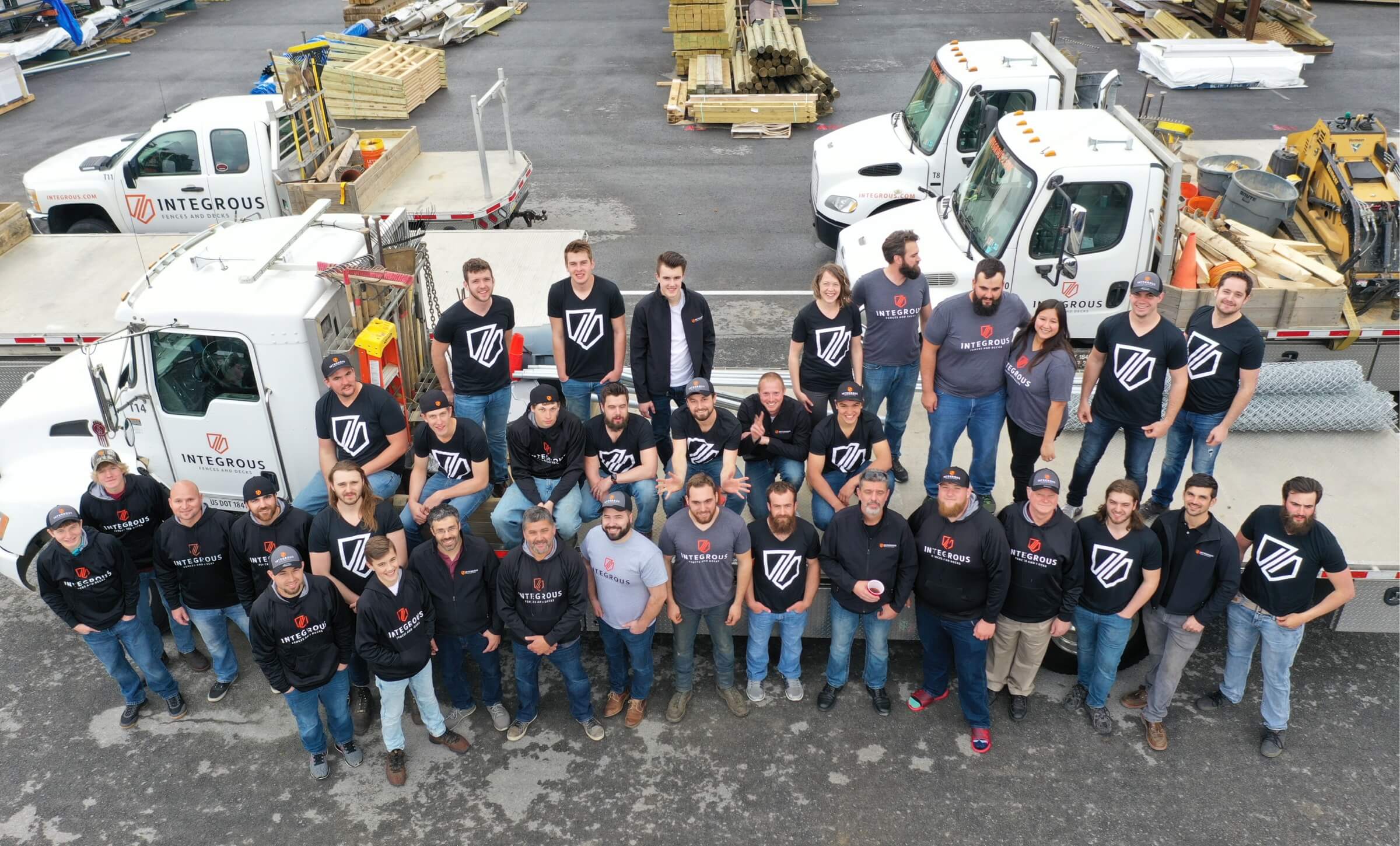 The entire Integrous team posing in front of their large flatbed truck