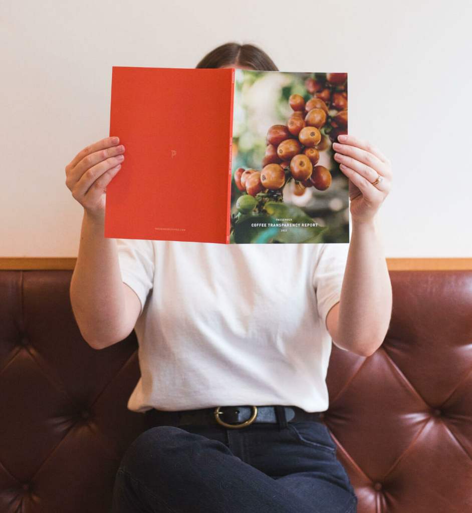 person sitting on a leather couch holding the Passenger Annual Report designed by Infantree