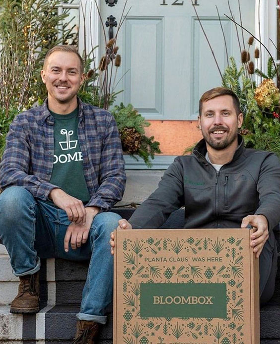 Chase & Dave, owners of BloomBox, holding their winter delivery box with winter arrangements