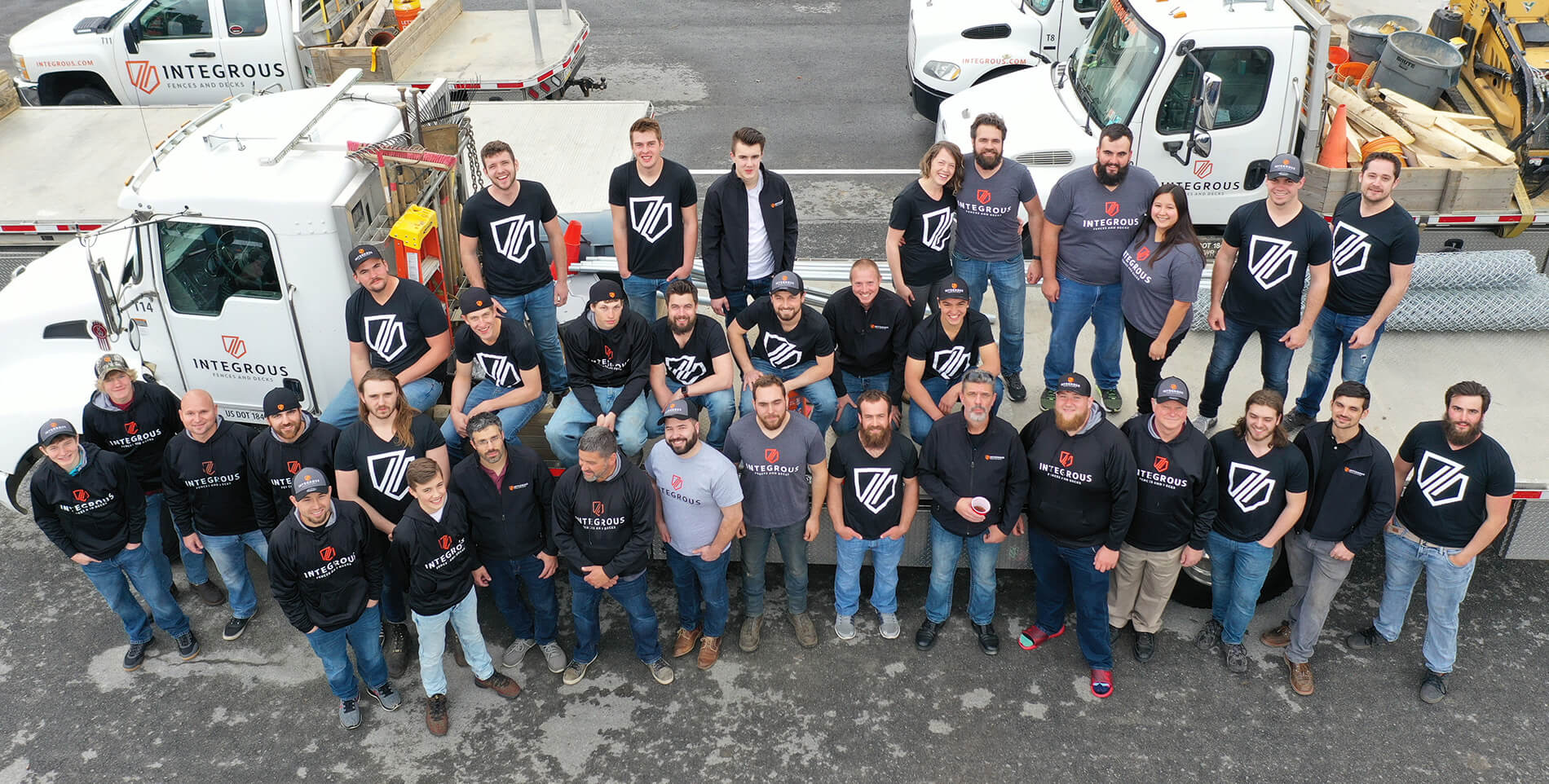 The Integrous team standing around a flat-bed truck wearing shirts with their new logo designed by Infantree