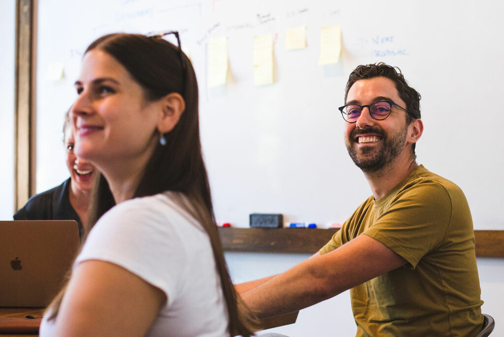 Art Director, Jordan High, and Account Coordinator Liz Rosenfeld laughing during an internal presentation at Infantree